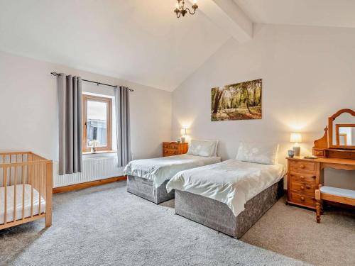 a bedroom with two twin beds and a crib at 4 Bed in Forton oc-81290 in Forton