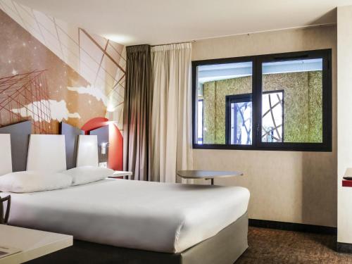 a hotel room with a large bed and a window at ibis Styles Poitiers Centre in Poitiers