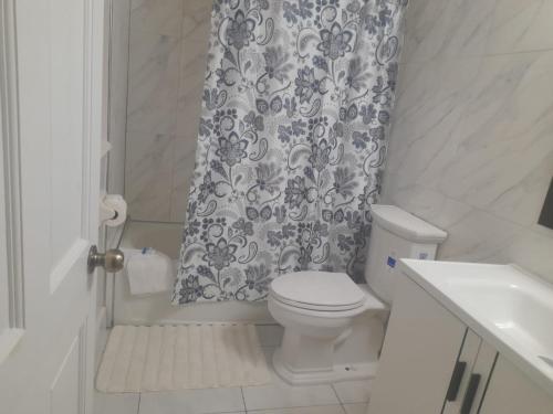 a bathroom with a toilet and a shower curtain at Mystic Ridge Ochi in Ocho Rios
