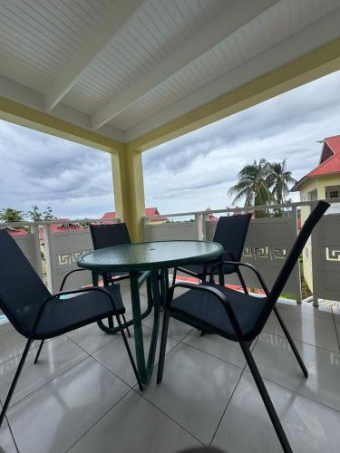 a table and chairs on a porch with a view at Mystic Ridge Ochi in Ocho Rios