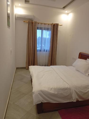 a bedroom with a large bed and a window at Résidence Prestige KGV Appt 302 in Douala
