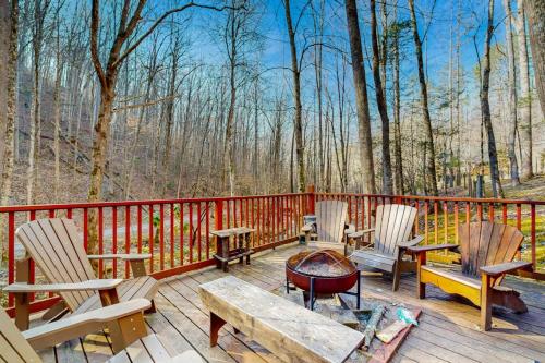 a wooden deck with chairs and a fire pit on it at Moose Creek Lodge in Sylva