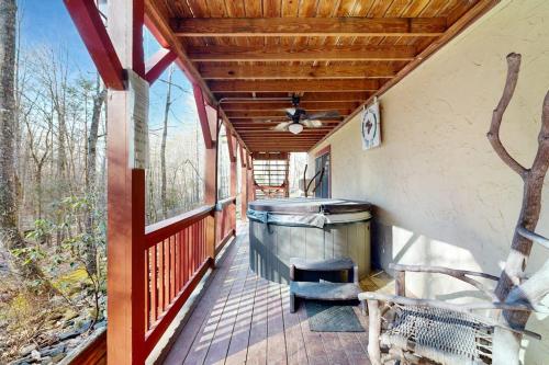 a screened porch with a ceiling fan and a bench at Moose Creek Lodge in Sylva