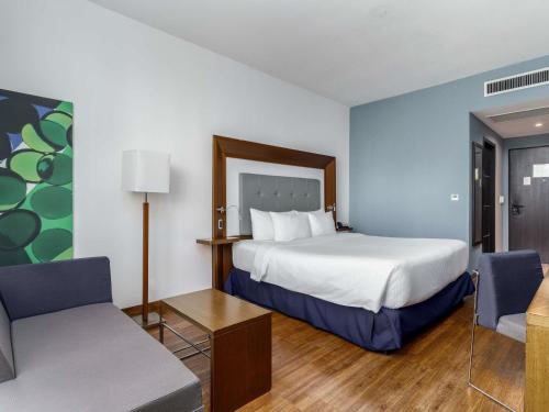 a hotel room with a bed and a couch at Novotel Panama City in Panama City