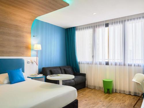 a hotel room with a bed and a chair at ibis Styles Montelimar Centre in Montélimar