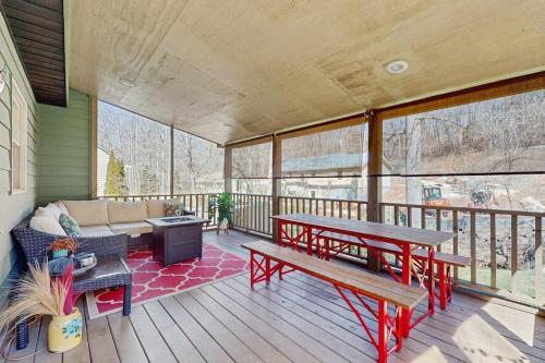 eine überdachte Veranda mit einer Bank und einem Tisch in der Unterkunft Ripple Run in Sylva