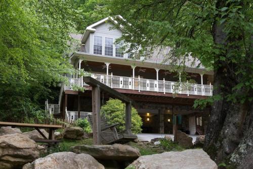 a large house with a porch and a deck at Above the River in Sylva