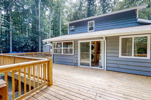 a blue house with a wooden porch and a deck at The Little Dude Cabin in Franklin