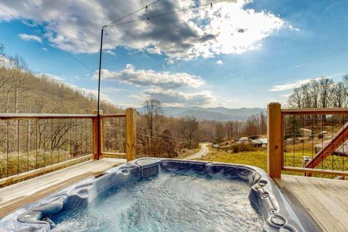 a hot tub on a deck with a view at Moss Creek Cabin in Sylva