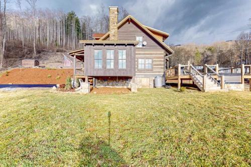 a house on a grassy field with a house at Moss Creek Cabin in Sylva