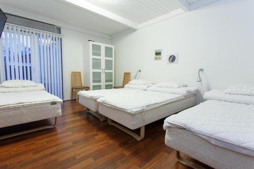 a room with three beds and a wooden floor at Give Apartment in Billund