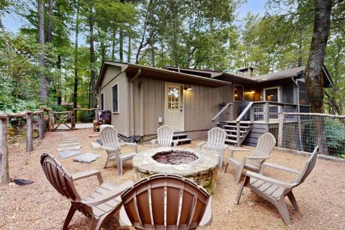 a cabin in the woods with a table and chairs at Campfire Hideaway in Highlands