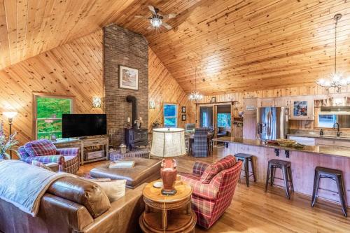 a living room with a couch and a kitchen in a cabin at The Treehouse in Franklin