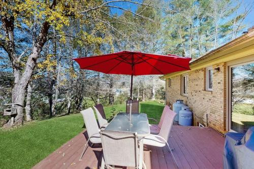 a patio with a table with a red umbrella at Shelba's Place in Sylva