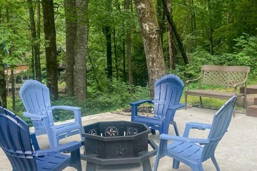 three blue chairs and a fire pit with a bench at Peak and Pond Retreat in Scaly Mountain