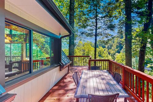 a deck with a wooden table and chairs on it at Chalet at Peek's Creek in Franklin