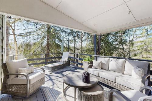 a screened in porch with a couch and chairs at Huckleberry Hill in Waynesville