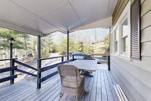 a patio with a table and chairs on a porch at Huckleberry Hill in Waynesville