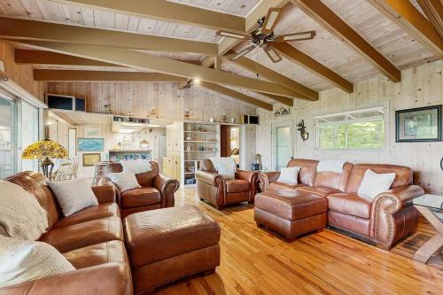 a living room with leather furniture and a ceiling fan at Vista Heights Retreat in Bryson City