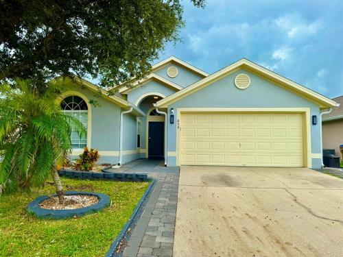 a house with a garage in front of it at Modern 4BR2BA with pool in gated community in Kissimmee