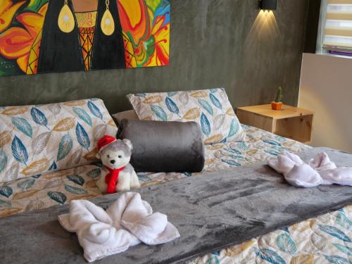 a teddy bear sitting on a bed with towels at La Marteja in Salento