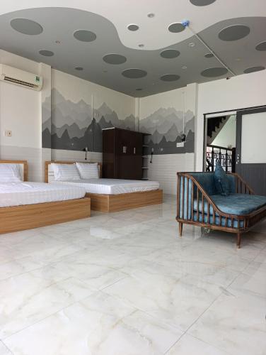 a bedroom with two beds and a couch in it at QN Home in Quy Nhon