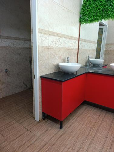 a bathroom with two sinks on a red counter at QN Home in Quy Nhon