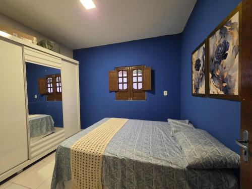 a blue bedroom with a bed and a window at Mirante in Crato