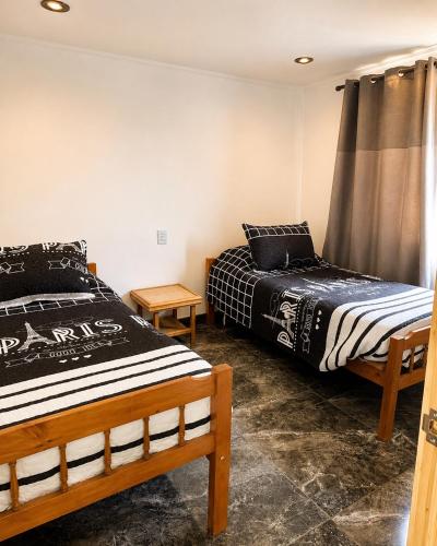 two beds sitting in a room withskirts at Cabaña bosquepaz in Algarrobo