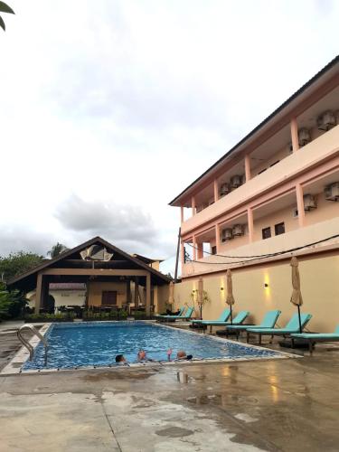 a swimming pool in front of a hotel at Aura Bluewave Beach House, Chenang in Pantai Cenang