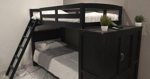 a black bunk bed with a ladder and a cabinet at reforma tecoman colima mexico in Tecomán