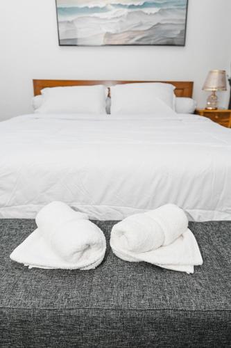two white towels are sitting on a bed at Dewandaru Homestay 2 in Tonogoro