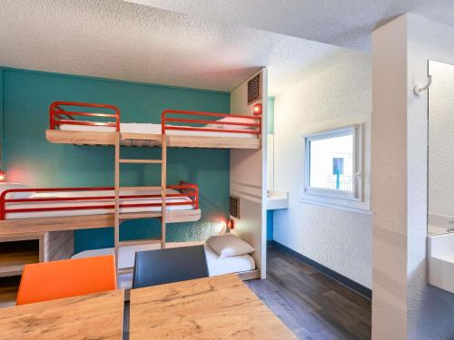 a room with bunk beds and a table and chairs at hotelF1 Metz Centre Devant les Ponts in Metz