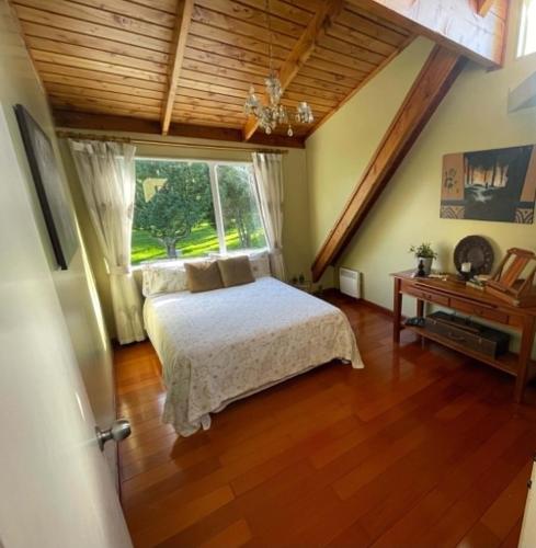 a bedroom with a bed and a window at MoonWillow Manor in Dairy Flat