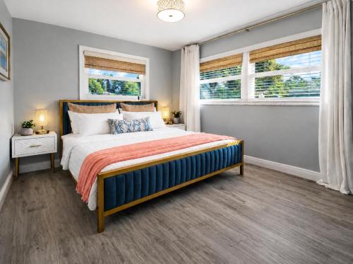 a bedroom with a bed and two windows at Tropical Dream - Pool - Firepit - Gazebo in Largo