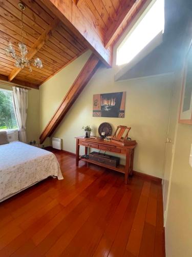 a bedroom with a bed and a wooden floor at MoonWillow Manor in Dairy Flat