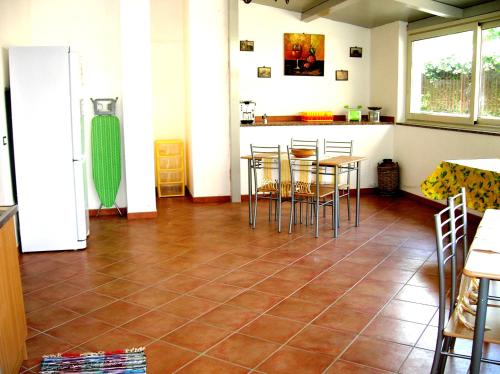 a kitchen with a tiled floor with tables and chairs at Casa mia in Calatabiano