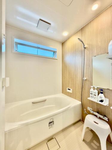 a bathroom with a bath tub and a sink at BookHouse in Takasaki