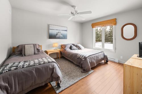 a bedroom with two beds and a window at La perle bleu in Rivière-à-Pierre