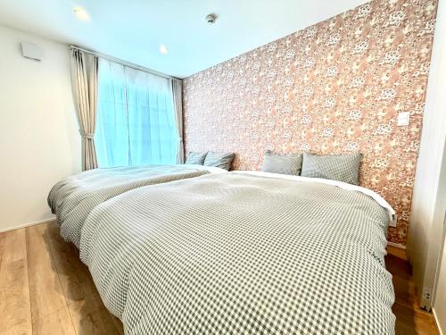two beds in a bedroom with a brick wall at BookHouse in Takasaki