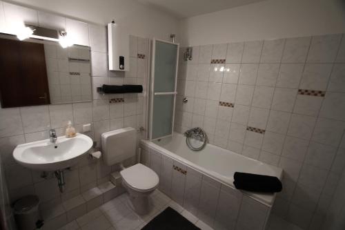 a bathroom with a sink and a toilet and a bath tub at Christianes Gästehaus in Düsseldorf