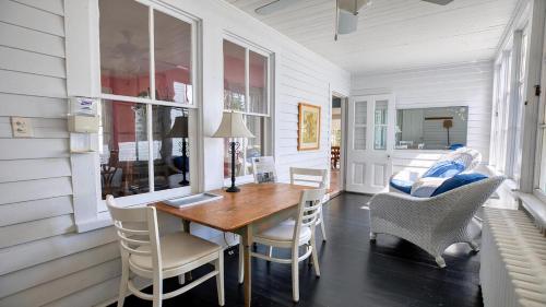 a dining room with a wooden table and chairs at Victorian On North in Cape May