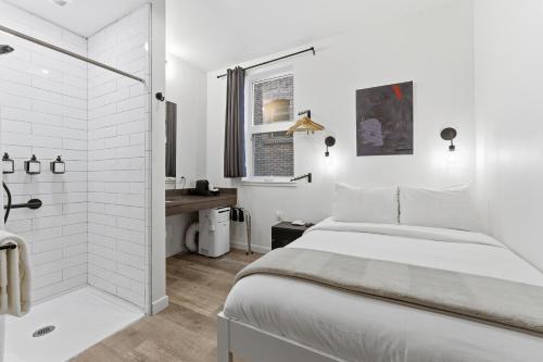 a white bedroom with a shower and a bed at The Boylston Hotel Capitol Hill in Seattle