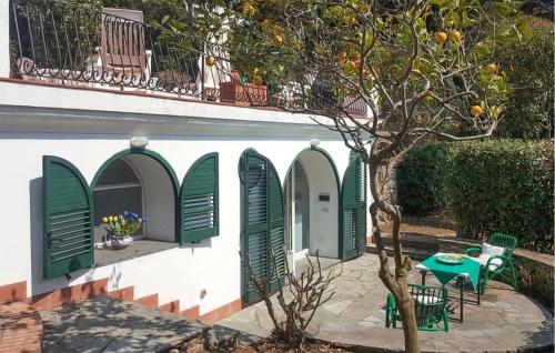 a building with green shutters and a table and a tree at Villa Marina in Anacapri