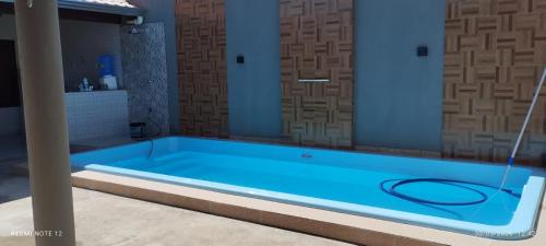 a blue swimming pool with a hose in a bathroom at beach house in Pontal de Coruripe in Coruripe