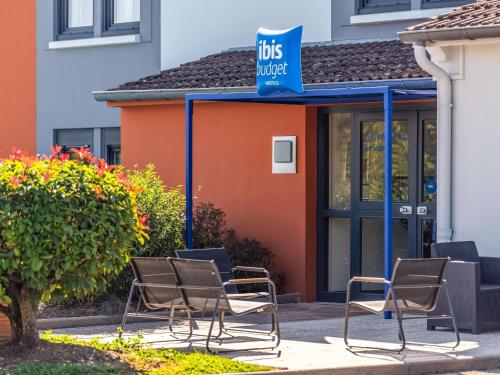a group of chairs sitting in front of a building at Ibis Budget Villefranche in Limas