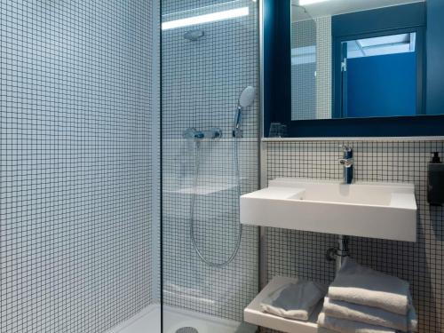 a bathroom with a shower and a sink and a mirror at Ibis Budget Saint Malo Centre in Saint Malo
