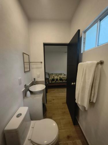 a bathroom with a white toilet and a sink at Casa Mango Jardin in San Francisco