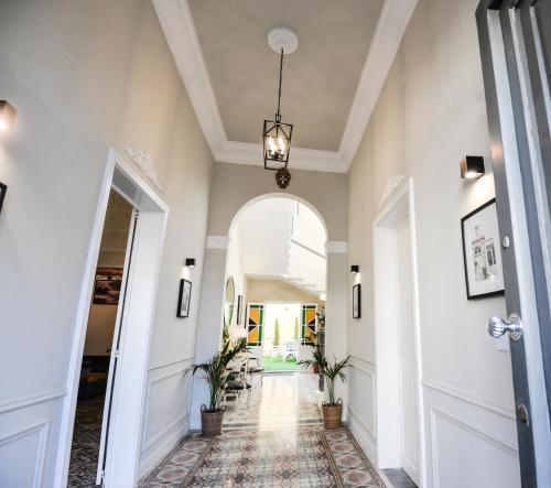 a hallway with an archway and a hallway with plants at Villa Dar Tfuliti in San Lawrenz