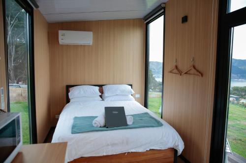 a bedroom with a bed with a laptop on it at Bayview Paradise by Tiny Away in Diamond Harbour